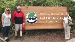 Biology Professor Scott Kight and 2 others pose at the entrance to the Galapagos