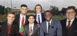Six members of the Red Hawk Sports Network pose wearing suits and ties