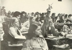 student in classroom raising hand