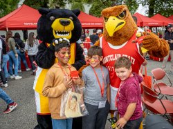Mascots Deacon and Rocky pose with children attending homecoming