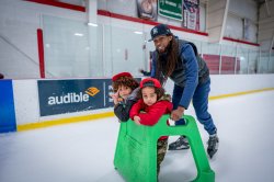 Man skates with two children.