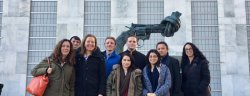 Image of Anthropology students and faculty members standing outside in front of a statue at the United Nations headquarters in Manhattan, New York.