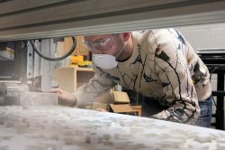 Student with respirator using CNC cutting table.