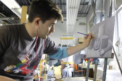 Student working on black and white still life painting