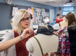Fashion Design Student Applying fabric to mannequin