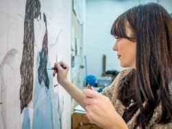 Female student drawing on canvas