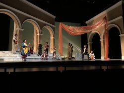 Annelise Lipowitz, as Festi, plays mandolin as ensemble looks on.