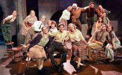 cast of urinetown poses on set opening night