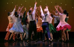 Image of students dancing on stage, promoting Spring Dance 2023