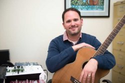 Image of Dr. Michael Viega holding a guitar