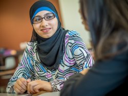 Student with hijab and glasses smiling