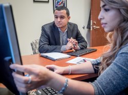 two people looking at computer monitor on desk