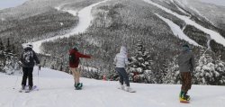 4 people snowboarding down a mountain