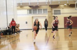 Montclair State University's women's club basketball team dribbling the ball down the court