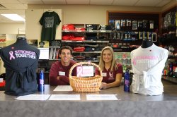 Two Equipment Checkout Attendants showing off the Breast Cancer Awareness Apparel for the month of October