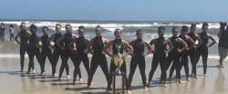 Dance team with trophy on beach
