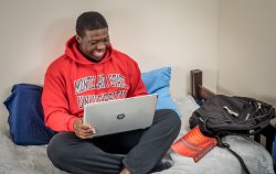 Student working on computer in dorm room.