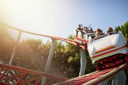 People riding roller coaster while wearing masks