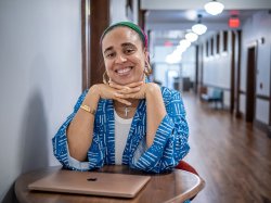 Cookie Howard sits at a table in a hallway in Susan A. Cole Hall.