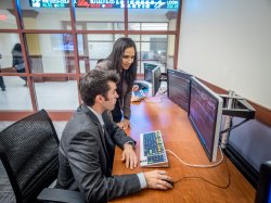 faculty member and student use specialist terminal in virtual trading floor