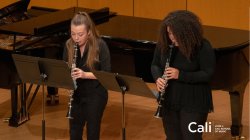 Two women playing clarinet on stage