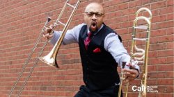 Trombonist jumping holding two trombones