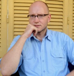 photo of writer Sándor Jászberényi, wearing a blue shirt