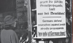 woman views Nazi propaganda posted in store window before World War II