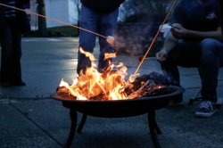 People roasting marshmallows over a fire pit