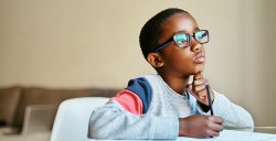 Image of a boy sitting at a desk at home for distance learning.