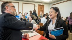 Student shaking hands with professional at Career Fair
