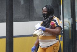 Amid COVID-19 concerns, a woman wears a bandana as she makes her way to catch a bus earlier this month. (AP Photo/LM Otero)