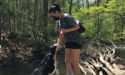 Photo of alumna Gina Ruiz wearing a mask while on a hike with her dog.