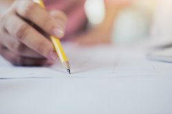 Photo of a hand using pencil on paper