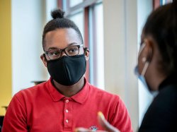 Photo of 2 students talking while wearing masks