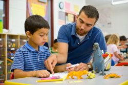 Photo of student and teaching learning with dinosaur toy