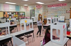 Maria Mirkovic works with some of her third graders in her classroom at Christa McAuliffe School in Jersey City, N.J., Thursday, April 29, 2021. (AP Photo/Seth Wenig)