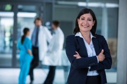 Photo of businesswoman standing in front of medical professionals