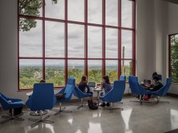 Students sitting by a window in the School of Communication and Media.