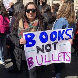 Protester holding sign that reads Books not Bullets