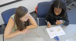 Two students working on coloring pages