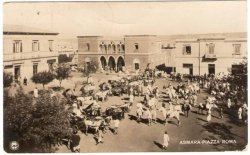 sepia toned image of Asmara Piazza Roma, with old buildings, horses and carriages