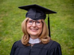 photo of Tracy Doyle '87 in cap and gown from Jun 3, 2022 Convocation ceremony