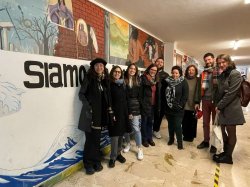 Select students and faculty involved in the seminar at UNIPA in front of a mural in the Humanities Department