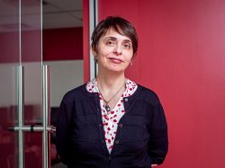 "Professor Anna Feldman stands against a red wall."