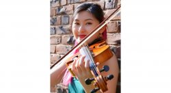 photo of Emily Wong. She is smiling and holding or playing a violin