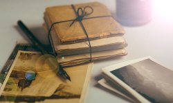 photo of old books and pictures with beam of light coming in from right