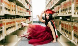 johanna cruz sits on the floor of library between library shelves