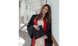 photo of Rozhan Shafiezadeh in her graduation gown, holding her graduation cap