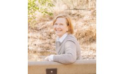 photo of Janis Hubschman smiling outside on a bench